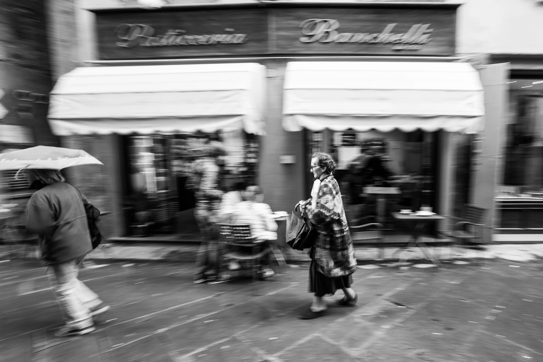 Black & white photo of people walking in the street