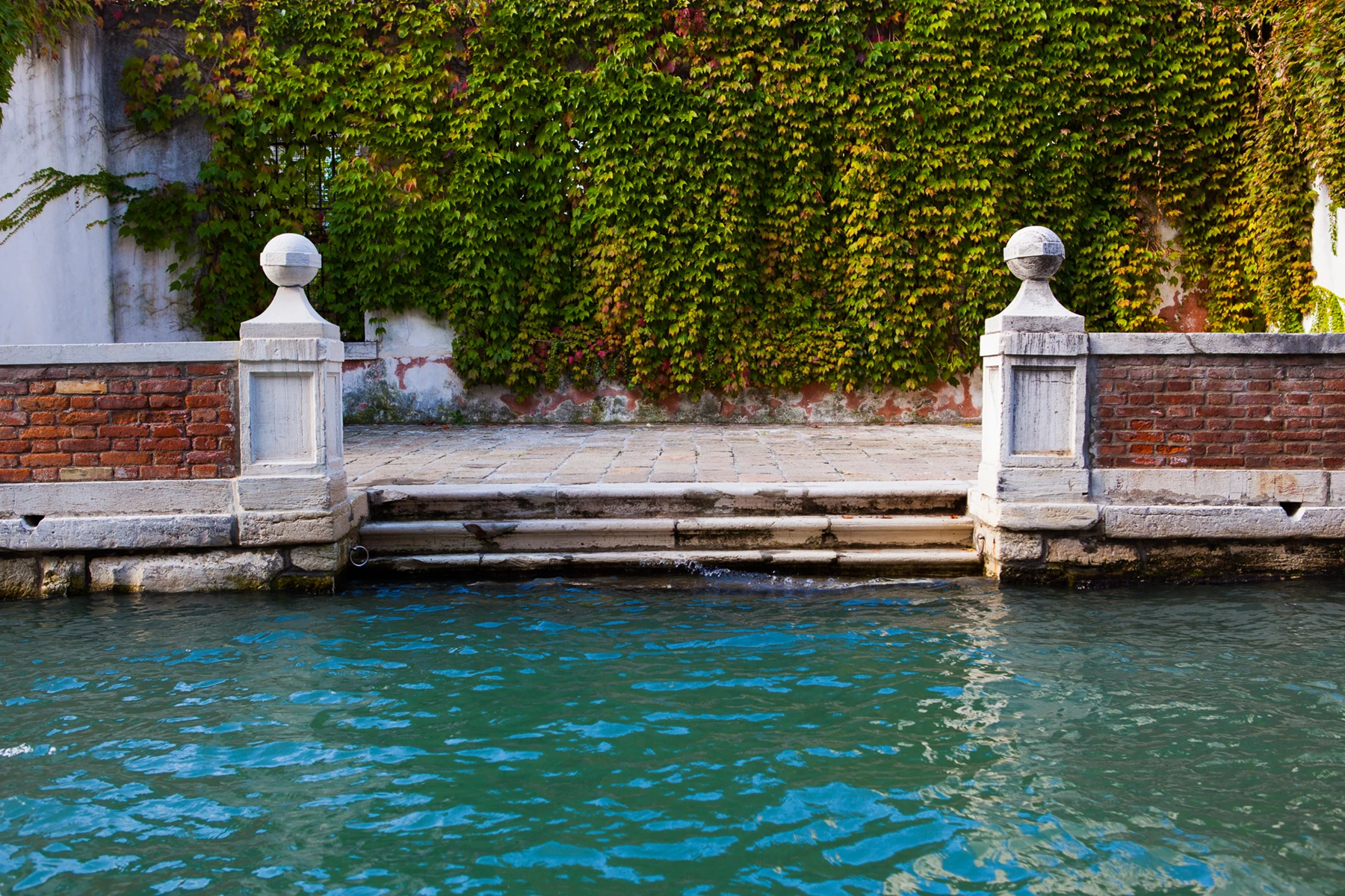 Colour photo of a pool of water with stone pillars