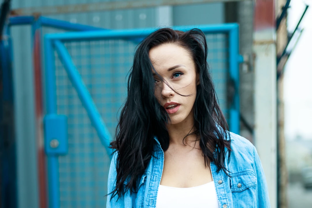 Lifestyle photo of woman standing in front of wire fencing