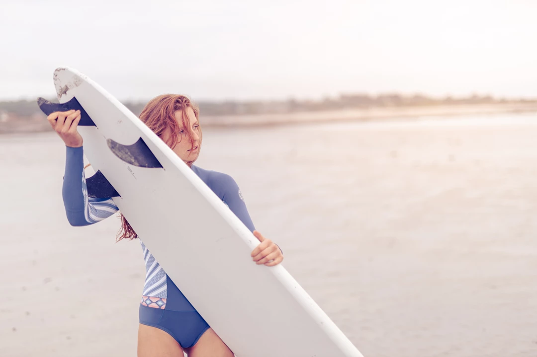 Colour photo of a person holding a surfboard